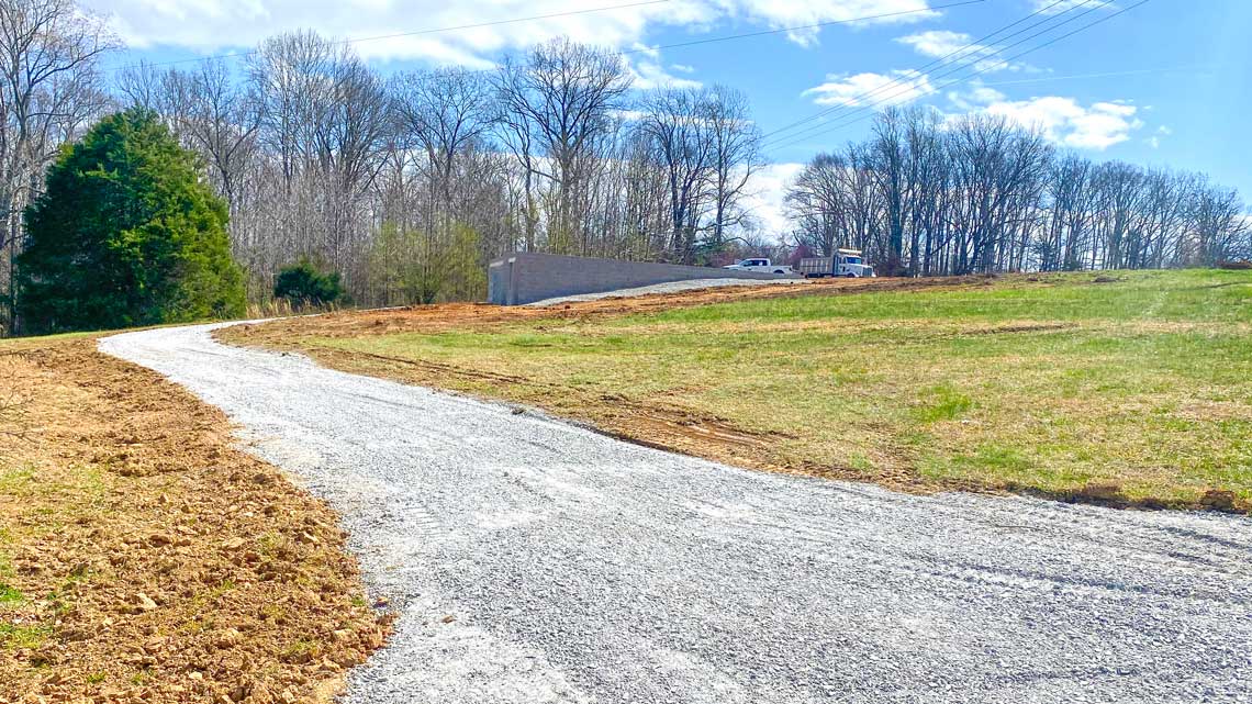 Gravel driveway leads to the new cabin site
